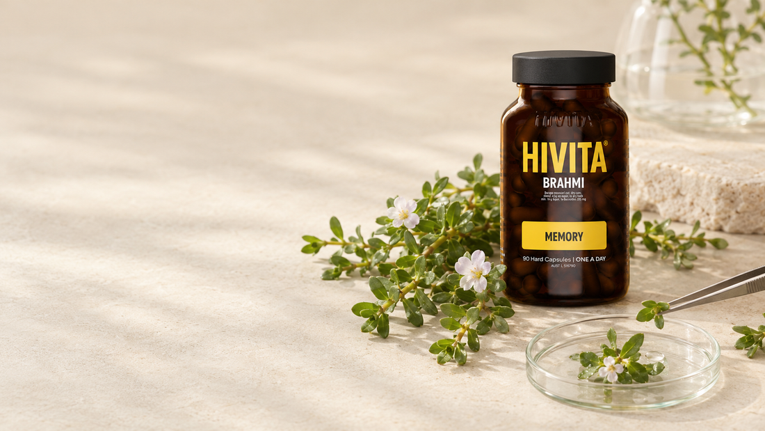 Fresh brahmi (Bacopa monnieri) leaves beside an amber Hivita Brahmi glass bottle in soft natural light